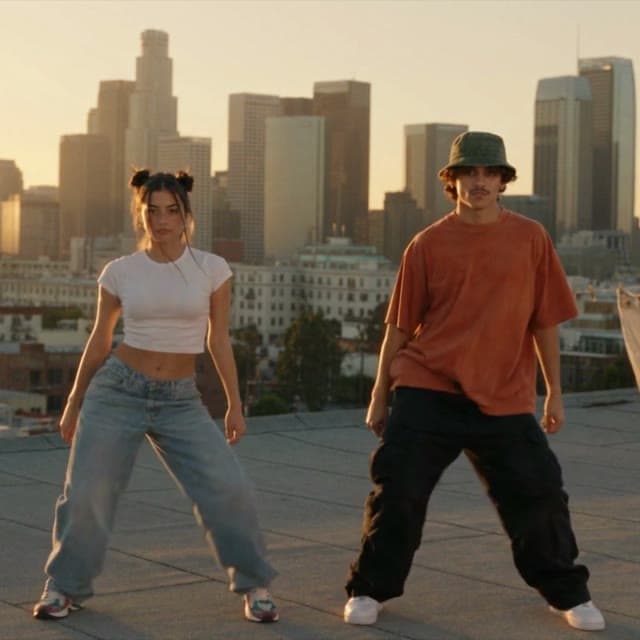 Reference video frame: two dancers on a rooftop at sunset